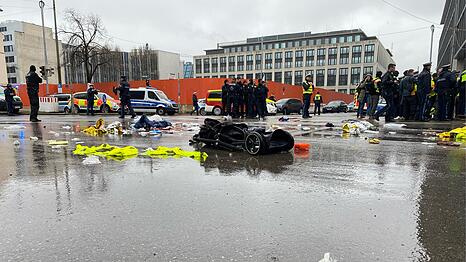 Das Epizentrum des Albtraums am schwarzen Donnerstag in M&uuml;nchen: An der Kreuzung Seidl-/Karlstra&szlig;e liegt kurz nach der Terrorfahrt am 13. Februar 2025 ein Kinderwagen v&ouml;llig demoliert auf der regennassen Stra&szlig;e. Im Vordergrund ein Turnschuh, der wohl einem der Opfer des Anschlags geh&ouml;rt.