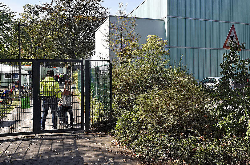 Ein Mitarbeiter eines Sicherheitsdienstes bewacht in Köln Porz den Zugang zu einer als Flüchtlingsunterkunft genutzten Turnhalle. Hier wurde am Dienstag ein 16-Jähriger Syrer festgenommen.