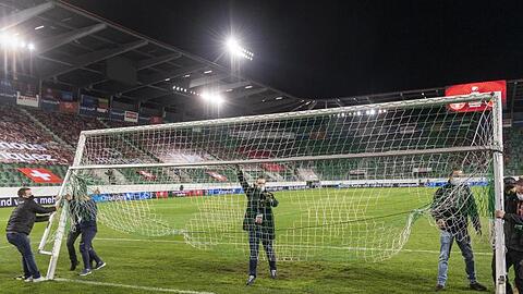 Mitarbeiter montieren vor Spielbeginn ein Ersatztor auf dem Spielfeld.