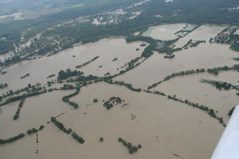 Er steht verloren inmitten einer Wasserlandschaft, die braunen Fluten reichen bis zum zweiten Stock.