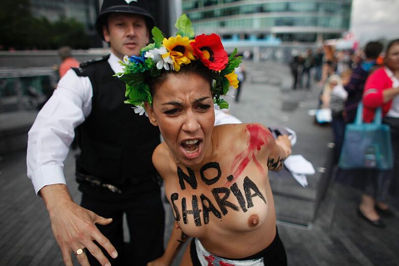 Nackte Tatsachen: Gewohnt freizügig protestierten Anhänger der feministischen Organisation Femen in London während Olympia - diesmal gegen islamistische Regimes und deren Unterstützung durch das olympische Kommitee. Da hatte die englische Polizei alle Hände voll zu tun.