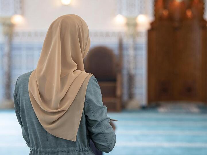 Eine Muslima mit einem Kopftuch im Gebetsraum einer Moschee.