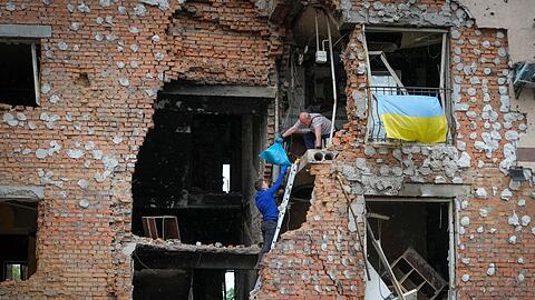 Bewohner holen ihre Habseligkeiten aus ihrem durch russischen Beschuss zerstörten Haus in Irpin.