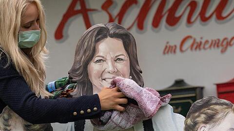 Eine Frau wischt das neu gemalte Porträt von Ilse Aigner (CSU), Präsidentin des bayerischen Landtags, mit einem Handtuch trocken. Foto: Peter Kneffel/dpa