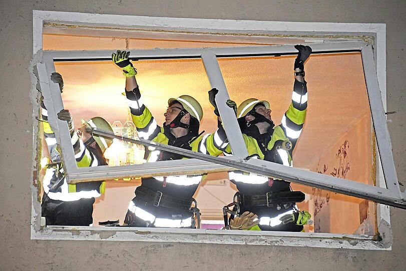 Feuerwehrleute sichern provisorisch die herausgesprengten Fenster.