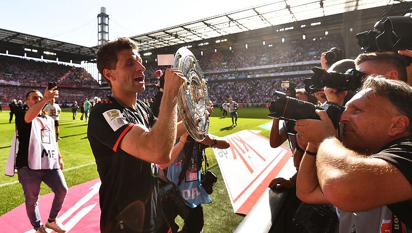 Bayerns Thomas Müller (M) jubelt mit der Meisterschale über den Gewinn der 33. deutschen Meisterschaft.
