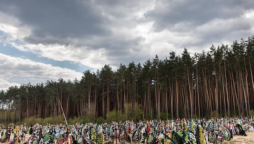 Zahlreiche Blumen und Fotos erinnern an frischen Gräber auf dem Friedhof in Irpin an dort begrabene Einwohner und Mitglieder der Territorialverteidigung, die bei der russischen Invasion in der Ukraine getötet wurden.