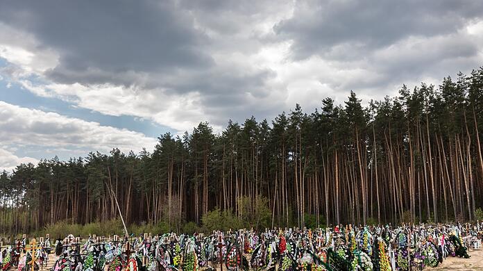 Zahlreiche Blumen und Fotos erinnern an frischen Gräber auf dem Friedhof in Irpin an dort begrabene Einwohner und Mitglieder der Territorialverteidigung, die bei der russischen Invasion in der Ukraine getötet wurden.