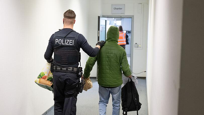 Ein Polizeibeamter bringt einen Mann zu einem Abschiebeflug nach Pakistan. (Archivfoto)