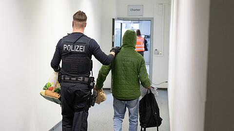 Ein Polizeibeamter bringt einen Mann zu einem Abschiebeflug nach Pakistan. (Archivfoto)