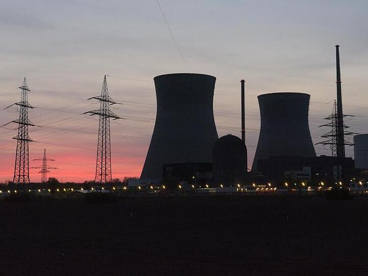 Die Kühltürme eines Atomkernkraftwerks zeichnen sich vor dem roten Himmel ab. Foto: Stefan Puchner/Archiv