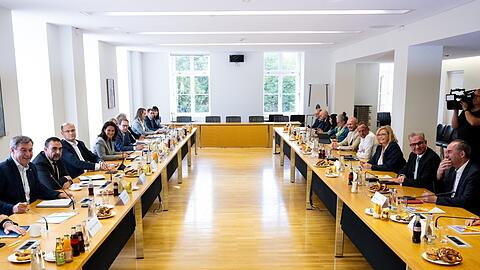 Hubert Aiwanger (r), Bundesvorsitzender der Freien Wähler, Markus Söder (l, CSU), Ministerpräsident von Bayern, und Mitglieder der beiden Parteien kommen im bayerischen Landtag zu den ersten Koalitionsgespräche zwischen CSU und Freien Wählern nach der Landtagswahl zusammen. Foto: Sven Hoppe/dpa