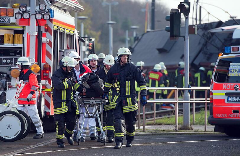 Eine verletzte Person wir aus der entgleisten Tram in Düsseldorf gebrogen und zu einem Krankenwagen gebracht.