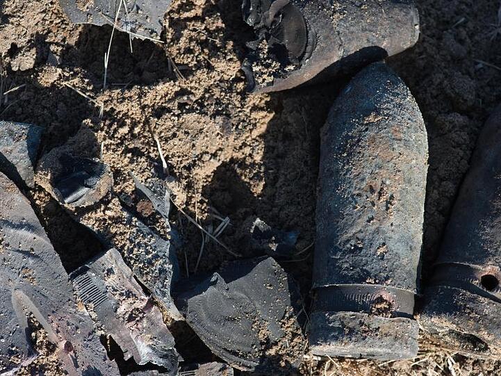 Granatsplitter und der ausgebrannte Granaten liegen auf einem Feld in Schönhausen, Sachsen-Anhalt.