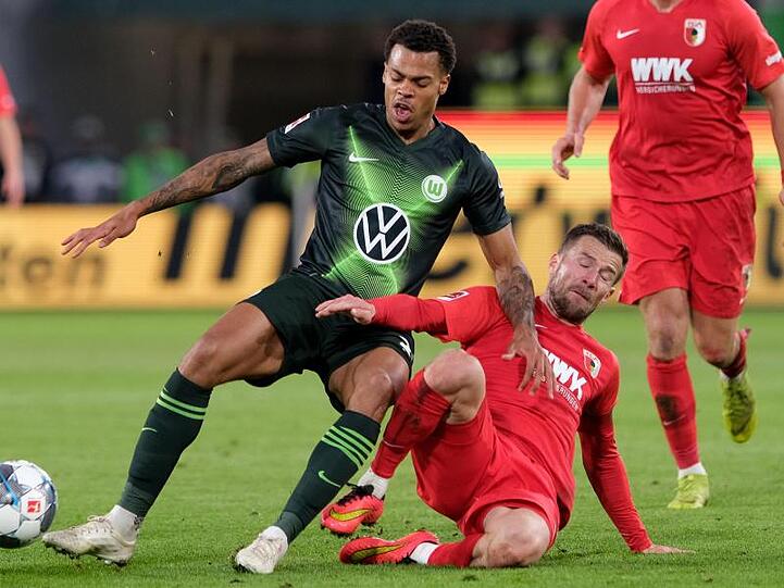 Augsburgs Daniel Baier (r) führt einen Zweikampf gegen Wolfsburgs Lukas Nmecha.