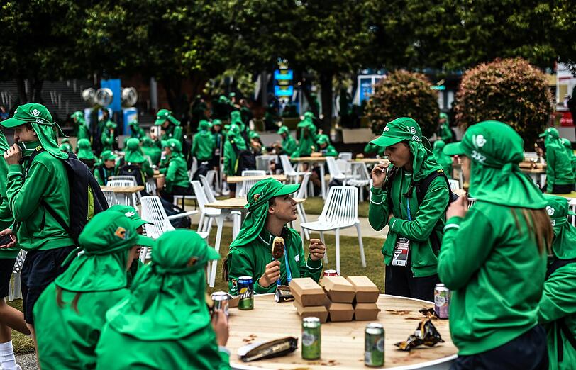 Aliens? Nein, die grün gewandeten Menschen sind Helfer und Ballkinder bei den Australian Open, die sich in einer Pause stärken.