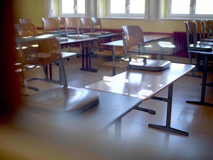 Hochgestellte Stühle stehen in einem Klassenraum. Foto: Britta Pedersen/Archiv