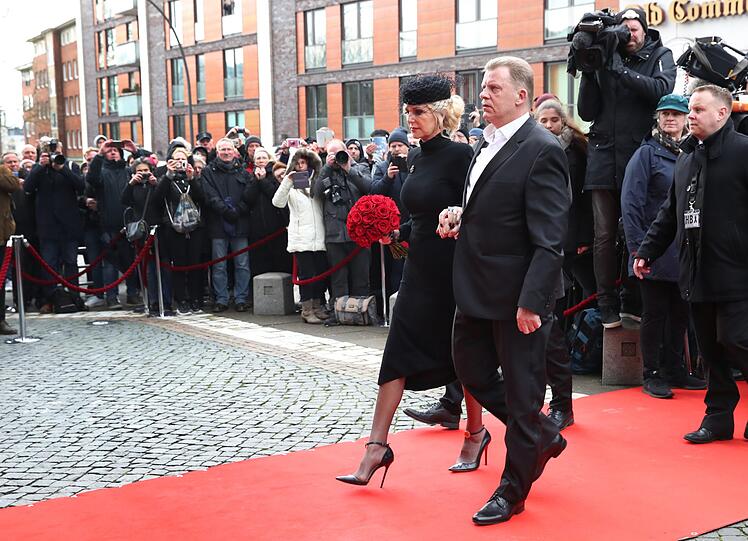 Marion, die Ehefrau von Jan Fedder, kommt mit einem großen Strauß aus roten Rosen zur Trauerfeier.