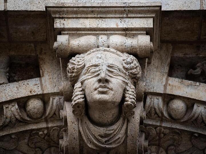 Die Göttin der Gerechtigkeit, Justitia, ist in das Mauerwerk des Landgerichts Bamberg eingearbeitet. Foto: Nicolas Armer/dpa/Archivbild