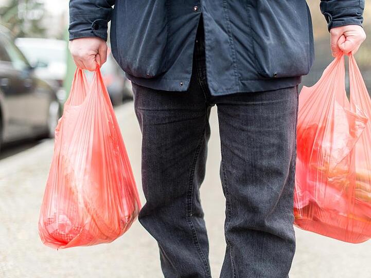 Ein Mann trägt seine Einkäufe in Plastiktüten nach Hause. Foto: Sebastian Gollnow/Archiv