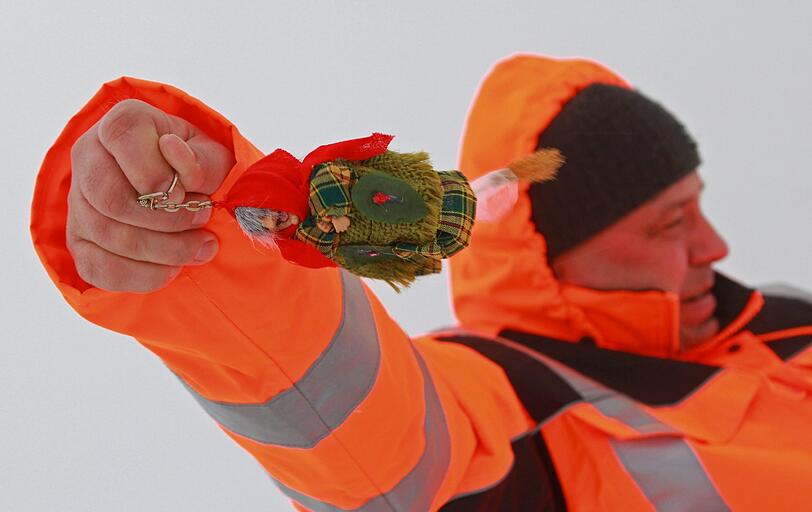 Ein Mitarbeiter des Brockenwirtes lässt eine Brocken-Hexe im Wind "fliegen"