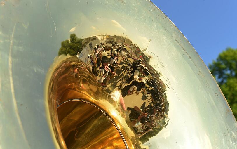 In einem Blasinstrument spiegelt sich am 25.04.2014 in München (Bayern) auf dem Frühlingsfest eine Musikkapelle.