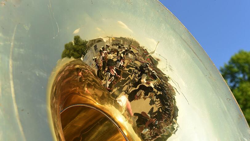 In einem Blasinstrument spiegelt sich am 25.04.2014 in München (Bayern) auf dem Frühlingsfest eine Musikkapelle. In einem Blasinstrument spiegelt sich am 25.04.2014 in München (Bayern) auf dem Frühlingsfest eine Musikkapelle.