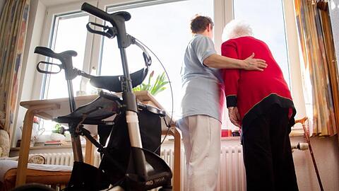 Eine Pflegerin blickt gemeinsam mit einer Bewohnerin eines Böblinger Pflegeheims aus dem Fenster.