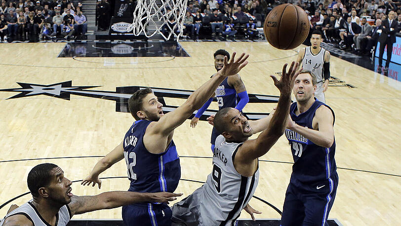 Comebacker Tony Parker von den San Antonio Spurs geht zwischen Maximilian Kleber (42) and Dirk Nowitzki (41) von den Dallas Mavericks zum Korb. Comebacker Tony Parker von den San Antonio Spurs geht zwischen Maximilian Kleber (42) and Dirk Nowitzki (41) von den Dallas Mavericks zum Korb.