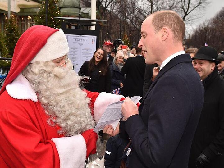 Der britische Prinz William (r) beim Besuch eines Weihnachtsmarkts in Helsinki.