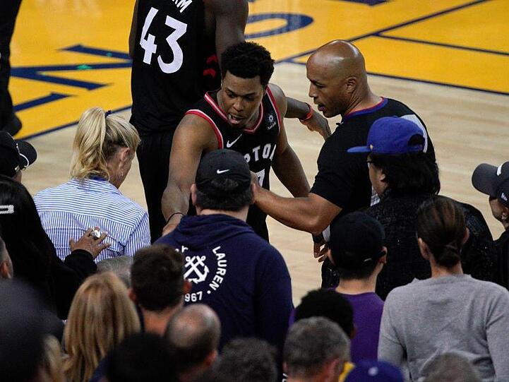 Kyle Lowry (M) von den Toronto Raptors beschwert sich neben Schiedsrichter Marc Davis über einen Fan.