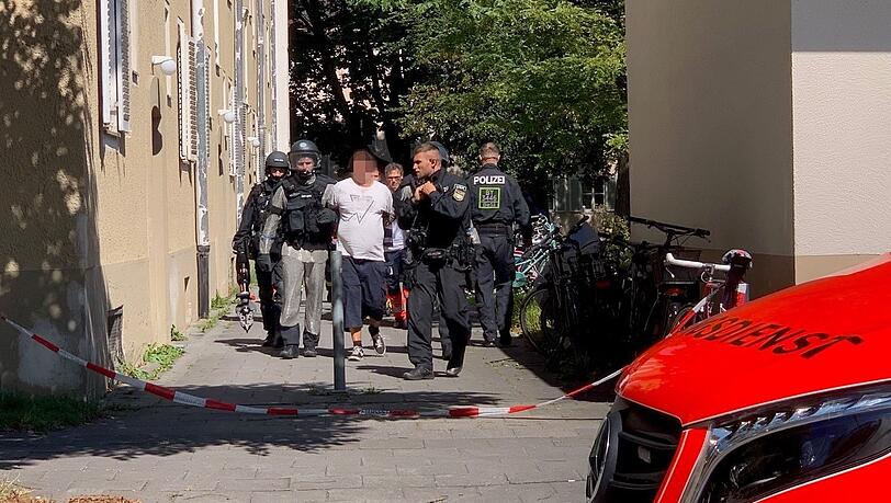 Spezialeinsatzkräfte führen den Verdächtigen am Mittag erneut ab.