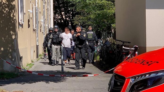 Spezialeinsatzkräfte führen den Verdächtigen am Mittag erneut ab.