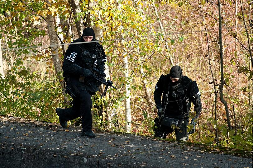 Schwer bewaffnet durchkämmen die SEK-Kräfte den BEreich um den Tatort...