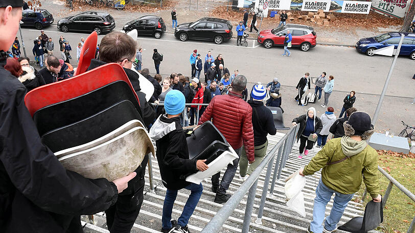 Was für Fußballromantiker: Fans des KSC tragen alte Sitzschalen aus der Baustelle Wildparkstadion.