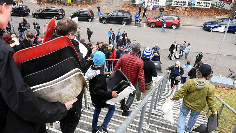 Was für Fußballromantiker: Fans des KSC tragen alte Sitzschalen aus der Baustelle Wildparkstadion.