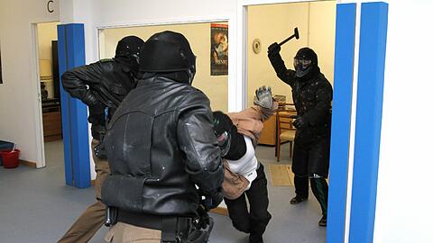 Hammer-Angriff! Ein Ausbilder simuliert in den Übungsräumen des Münchner Präsidiums eine lebensgefährliche Attacke - gleich werden die Beamten schießen.