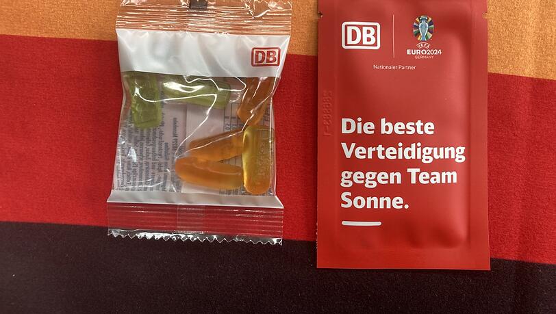 Ein Päckchen Süßes und ein Schuss Sonnencreme für die Fußballfans in München: der Willkommensgruß der Bahn. Ein Päckchen Süßes und ein Schuss Sonnencreme für die Fußballfans in München: der Willkommensgruß der Bahn.