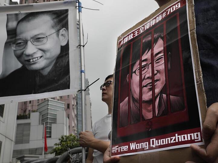 Demonstranten halten Plakate mit dem Bild des gestorbenen chinesischen Friedensnobelpreisträgers Liu Xiaobo (l) und des inhaftierten Menschenrechtlers Wang Quanzhang während einer Protestkundgebung im Juli 2018.