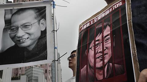 Demonstranten halten Plakate mit dem Bild des gestorbenen chinesischen Friedensnobelpreisträgers Liu Xiaobo (l) und des inhaftierten Menschenrechtlers Wang Quanzhang während einer Protestkundgebung im Juli 2018.