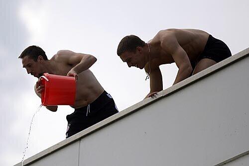 Franck Ribéry (l.) und Lukas Podolski kippen aus Jux Wasser über ihre Spieler-Kollegen.