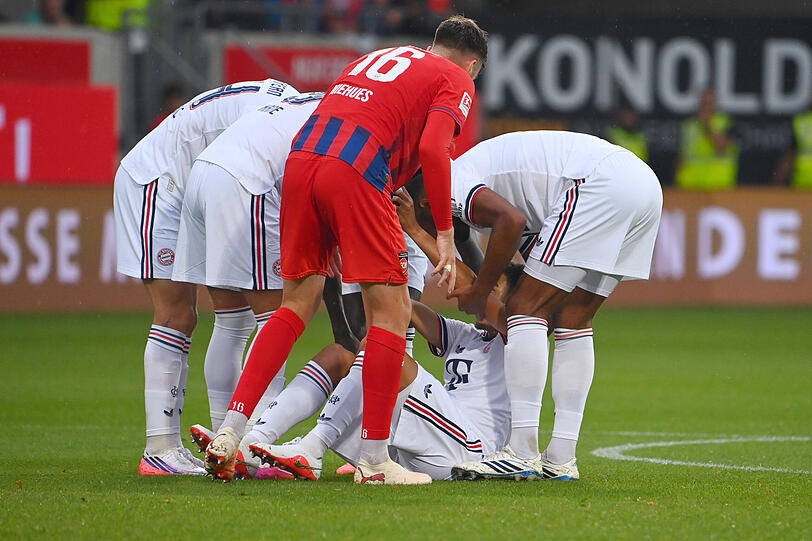 Die Bayern-Spieler helfen Musiala. Die Bayern-Spieler helfen Musiala.