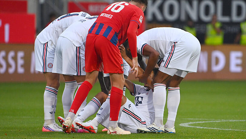 Die Bayern-Spieler helfen Musiala. Die Bayern-Spieler helfen Musiala.