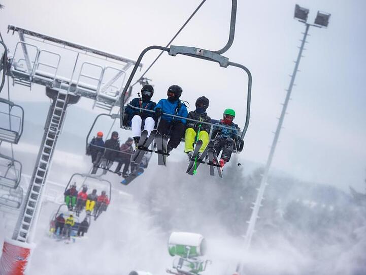 Skifahrer sitzen auf einem Sessellift. Foto: Christophe Gateau/Archiv