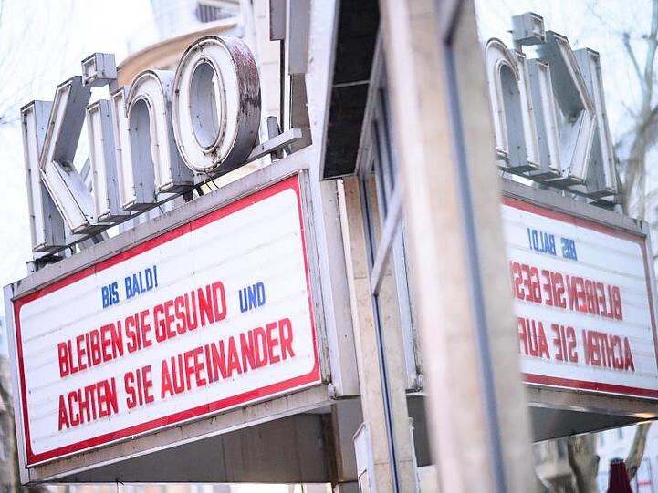 An einem geschlossenen Kino steht "Bis Bald! Bleiben sie gesund und achten Sie aufeinander".