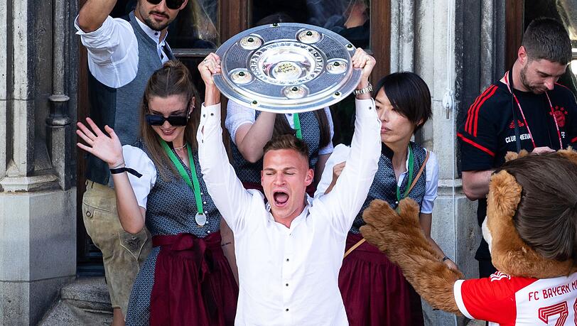 Bayerns Joshua Kimmich (M) jubelt mit der Meisterschale auf dem Rathaus-Balkon.