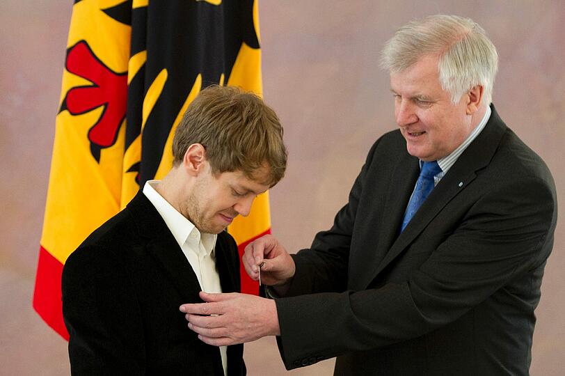 Die Urkunde sieht nicht aus wie ein silbernes Lorbeerblatt. Wohl aber die Anstecknadel, die Seehofer in der Hand hält.
