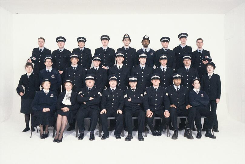 Auf dem Gruppenbildnis schauen 26 Männer und Frauen in Polizeiuniformen stumm, aber eindringlich die Betrachter an. Das Porträt ist keine Fotografie, sondern ein Film.