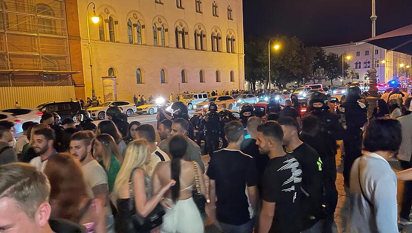 Im Hintergrund sind Polizisten mit Helm zu sehen. Im Hintergrund sind Polizisten mit Helm zu sehen.