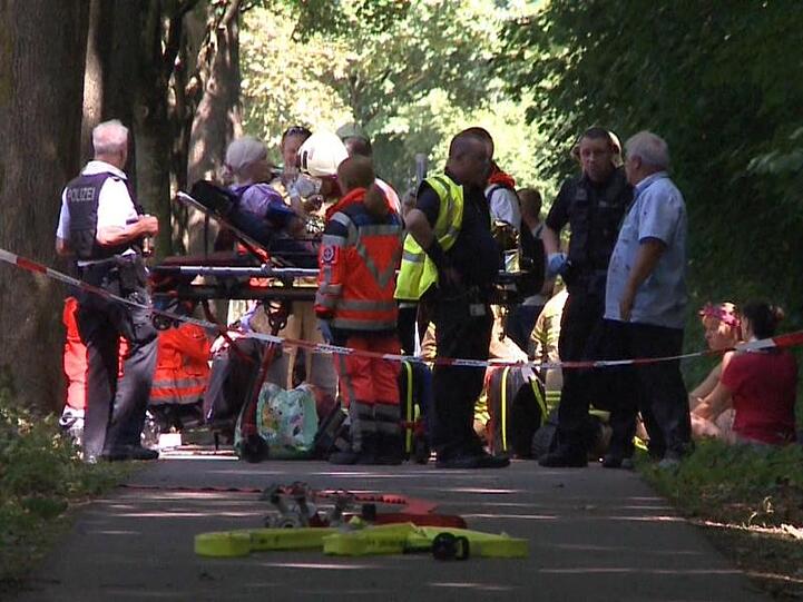 Hinter einer Polizeiabsperrung werden die verletzten Fahrgäste des Linienbusses versorgt.